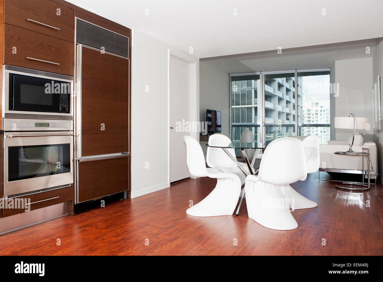 Dining table, oven and cabinets in modern kitchen Stock Photo - Alamy