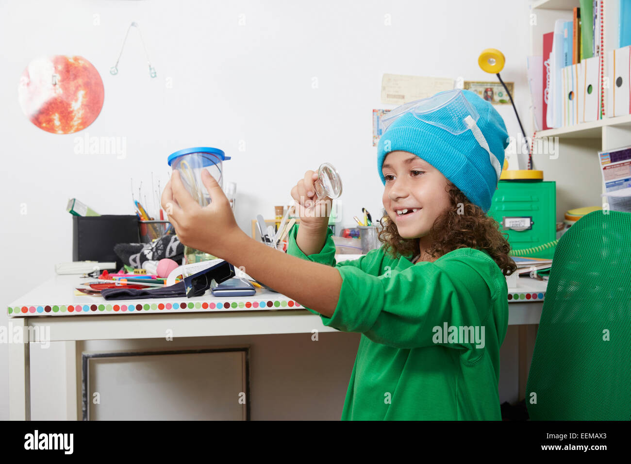 Mixed race girl doing science experiments at desk Stock Photo
