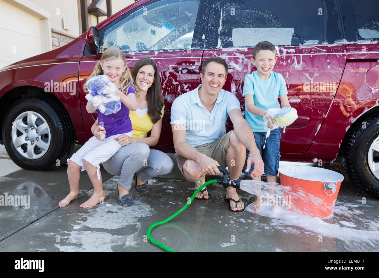Caucasian family washing car in driveway Stock Photo Alamy