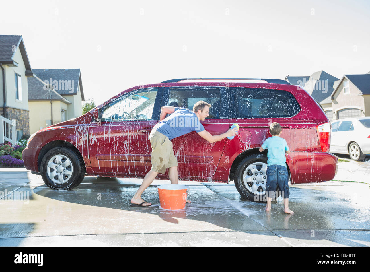 Caucasian father and son washing car in driveway Stock Photo Alamy