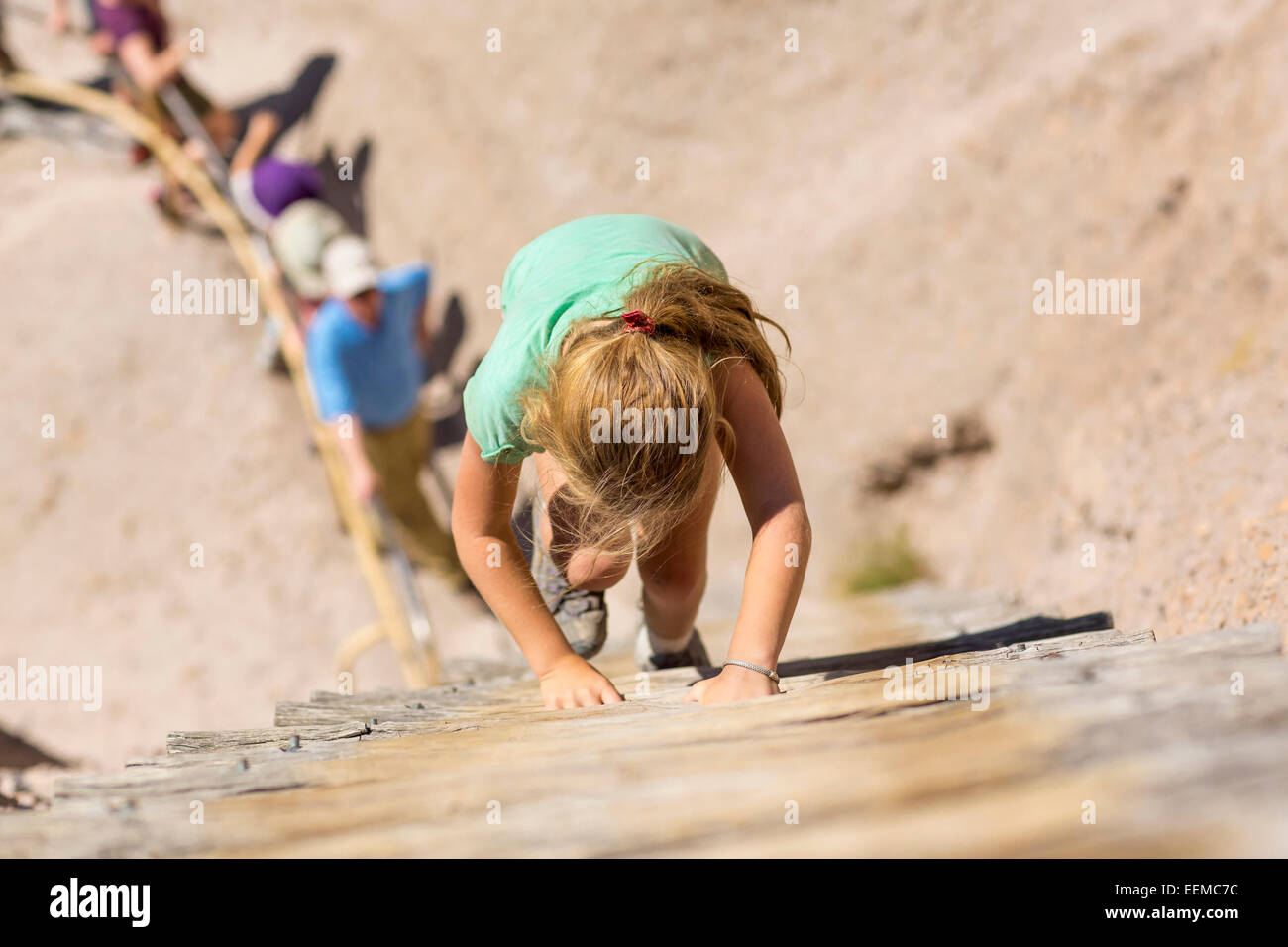 Caucasian girl climbing wooden ladder on hillside Stock Photo Alamy