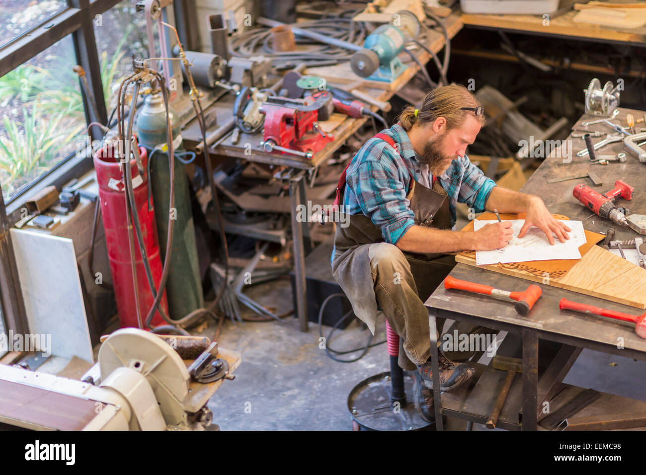 Caucasian craftsman working in workshop Stock Photo