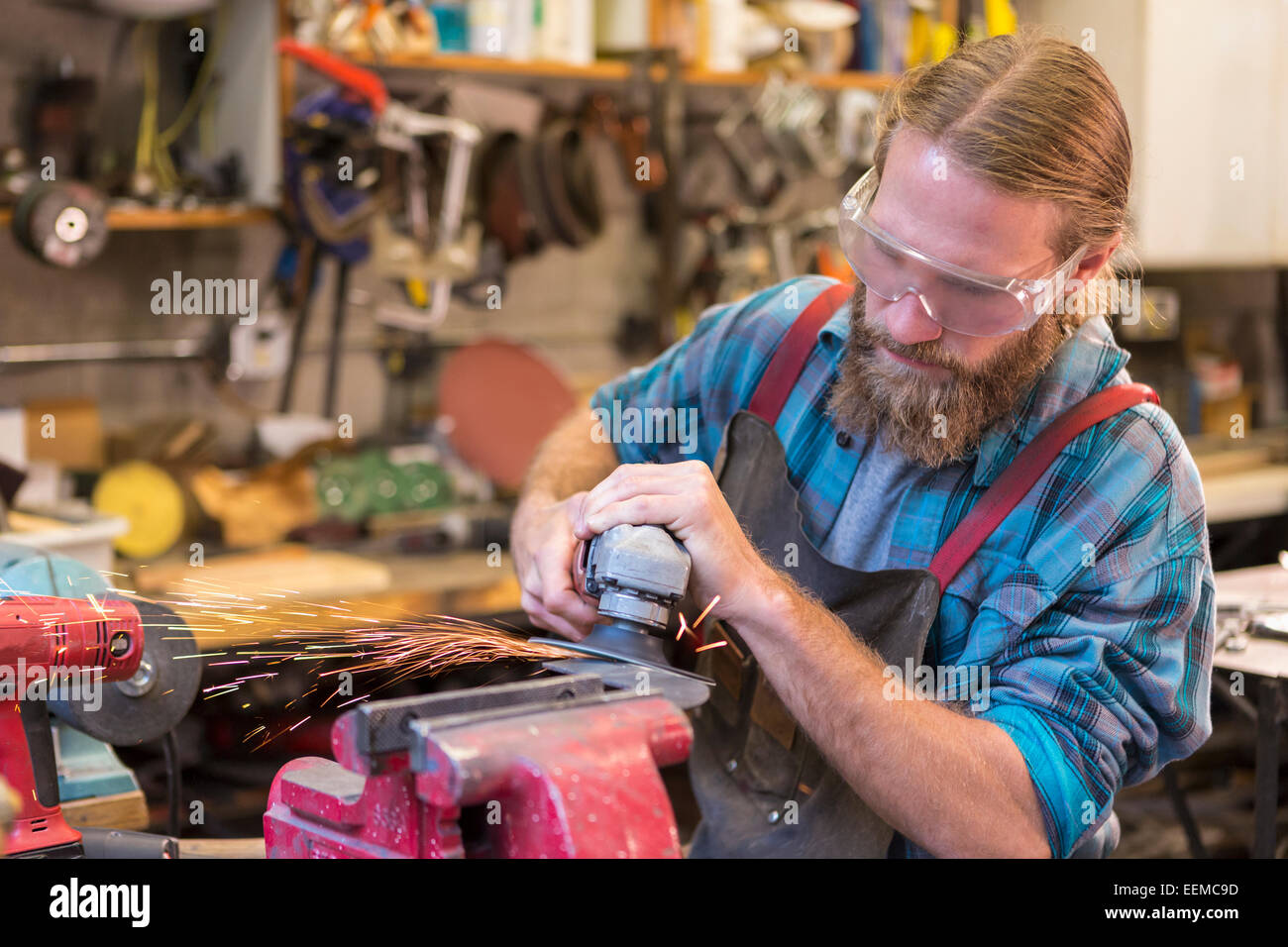 Caucasian craftsman grinding in workshop Stock Photo