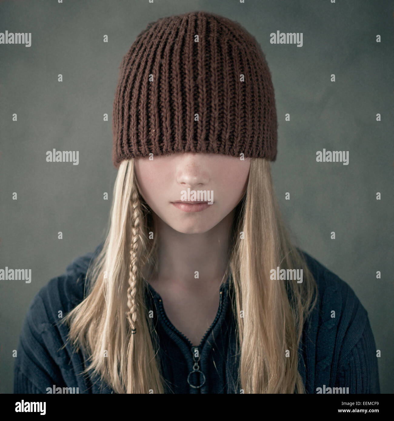 Teenage girl wearing knitted cap over eyes Stock Photo