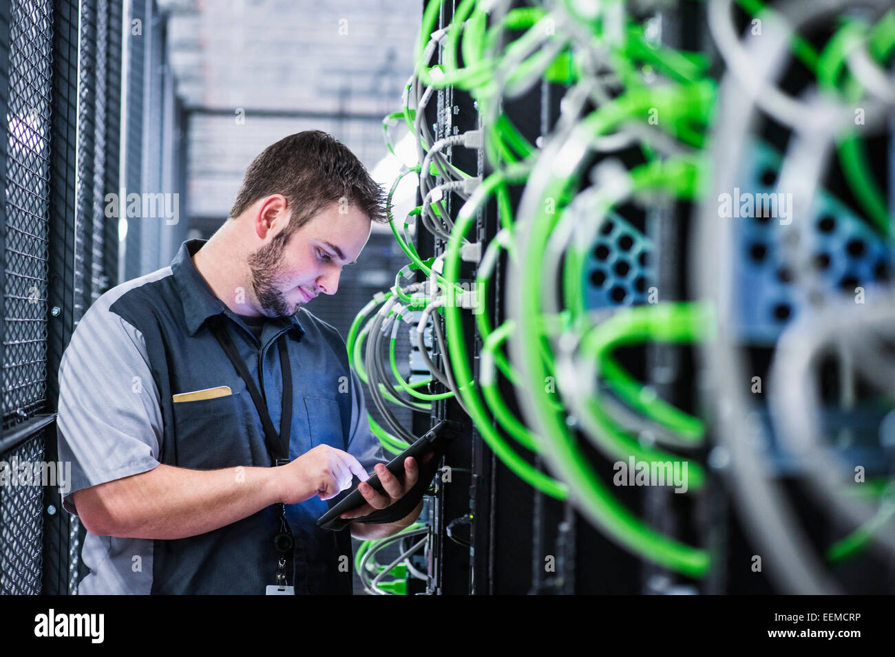 Caucasian technician using digital tablet in server room Stock Photo