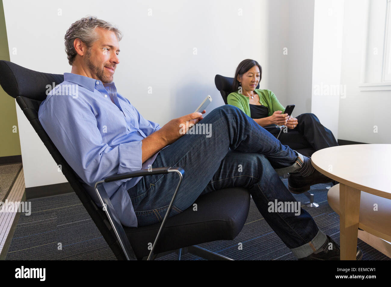 Business people using cell phones in office Stock Photo