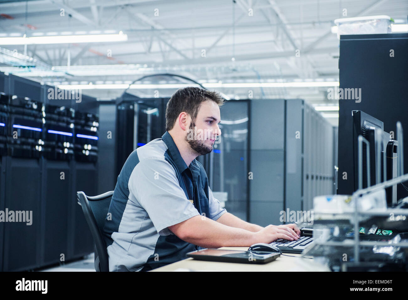 Caucasian technician using computer in server room Stock Photo