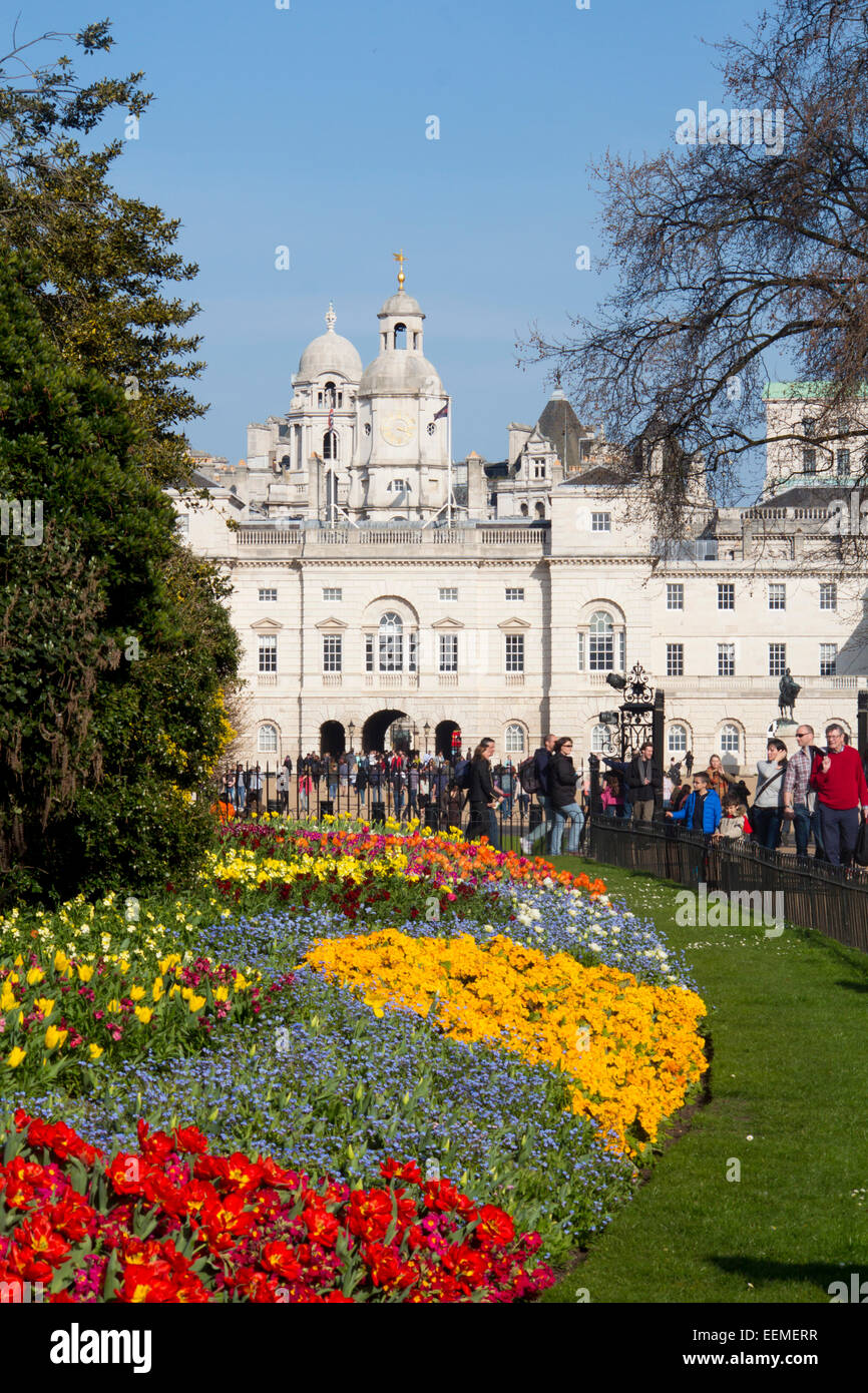 St James's Park flower beds with tulips in spring looking towards Horseguards Parade with people walking by Westminst Stock Photo