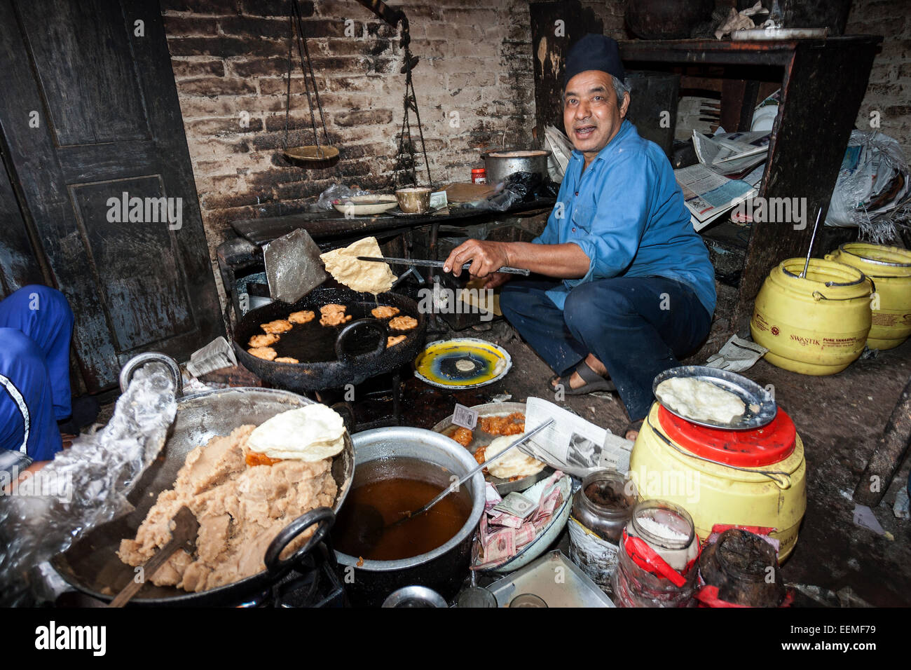 Nepalese man producing fried food, Bhaktapur, Nepal Stock Photo