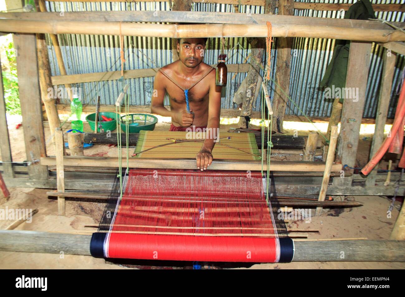 Bangladesh 10 January 2015. A Tribal man weaving cloth on an old traditional loom. Stock Photo