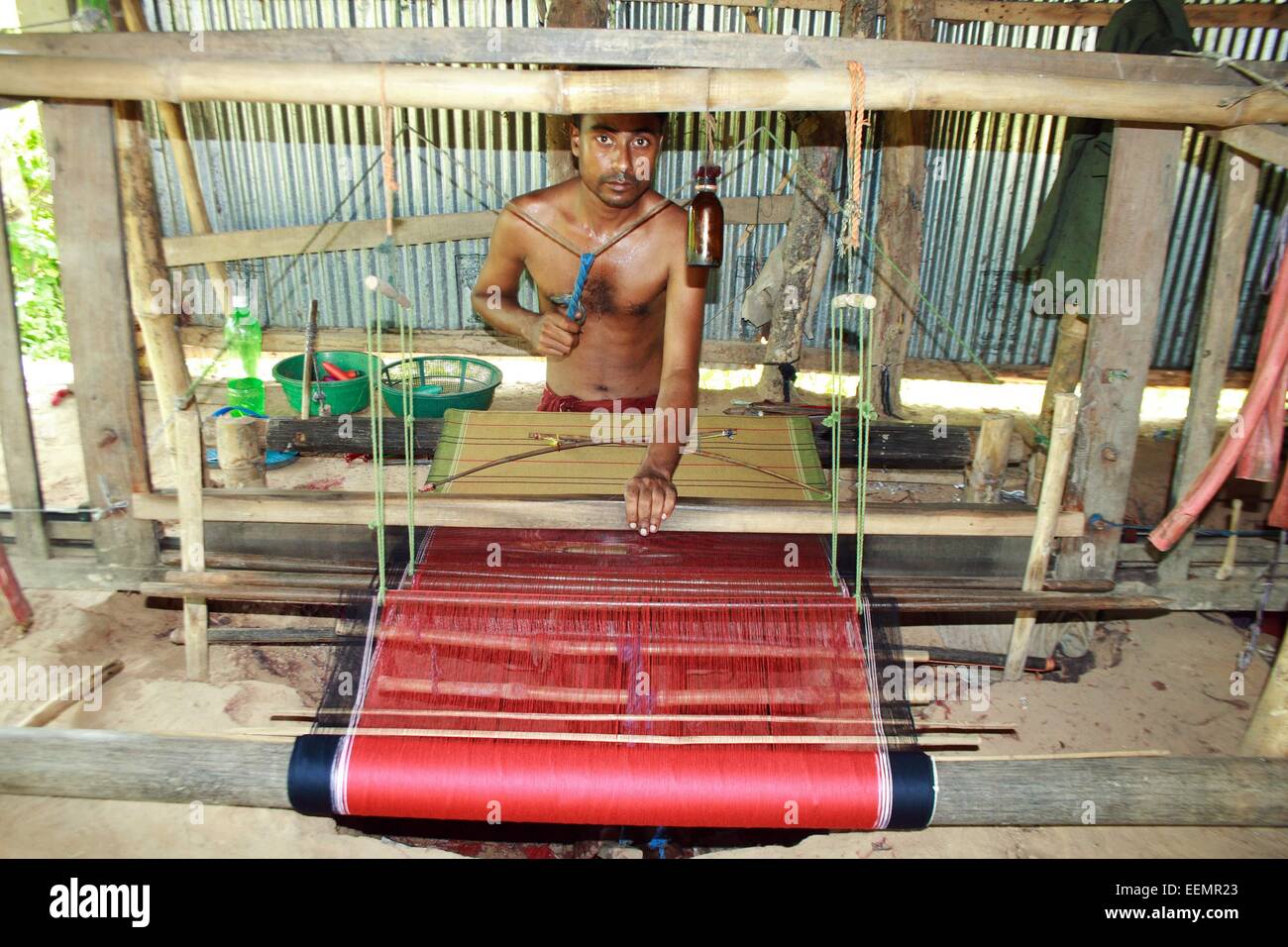 Bangladesh 10 January 2015. A Tribal man weaving cloth on an old traditional loom. Stock Photo