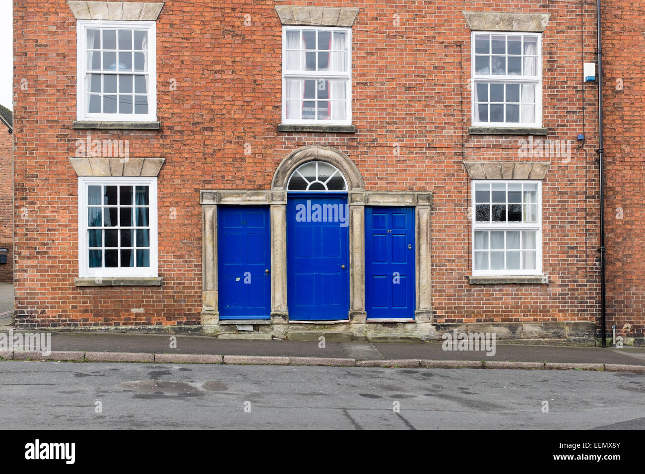 Bright blue painted doors on a Georgian red brick building in the Derbyshire town of Melbourne Stock Photo
