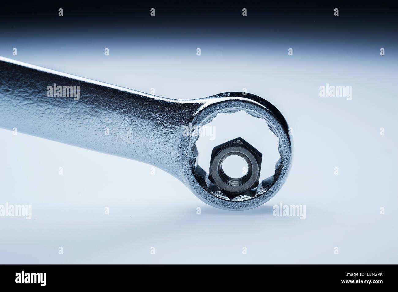 Wrong sized wrench for hex nut mismatch metaphor on graduated background Stock Photo