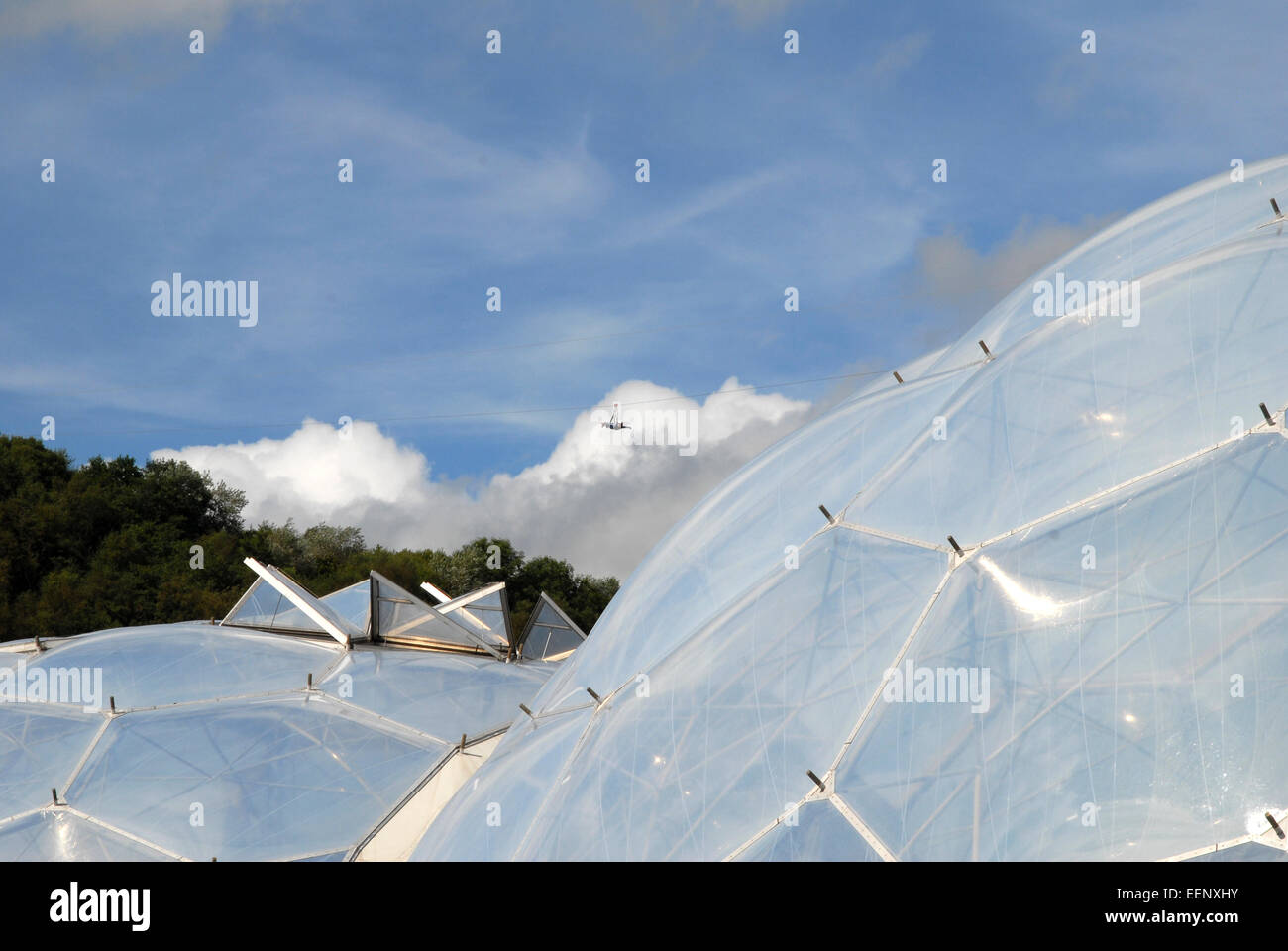 Eden Project, Cornwall, UK, with visitor flying over the biomes on the zip wire Stock Photo