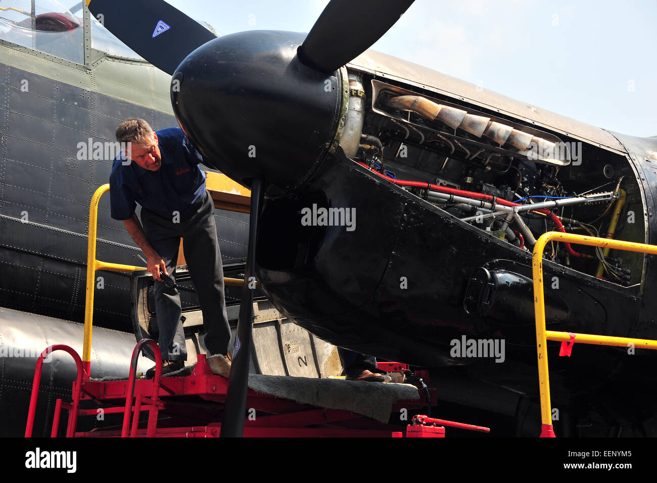 A mechanic inspects the engine of an airworthy Lancaster bomber in