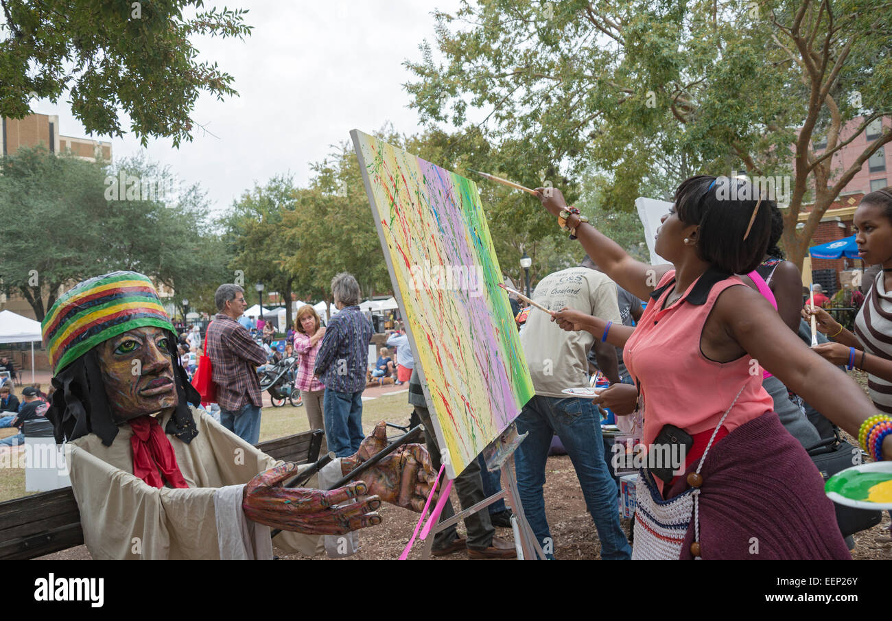 Downtown Art Festival in Gainesville, Florida.  Here Haitian artist helps others to discover their inner creativity. Stock Photo