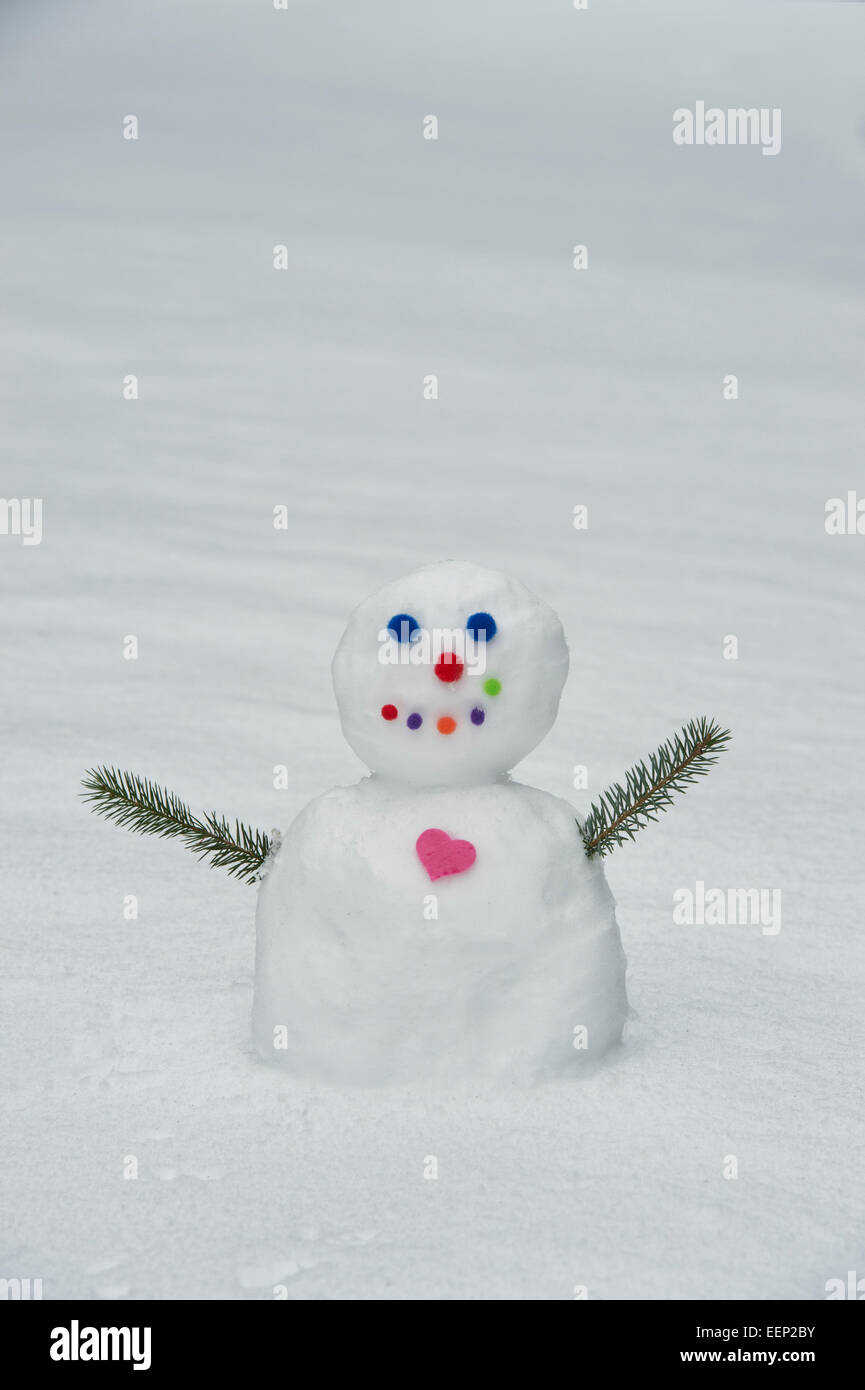 Colourful snowman with a big heart Stock Photo