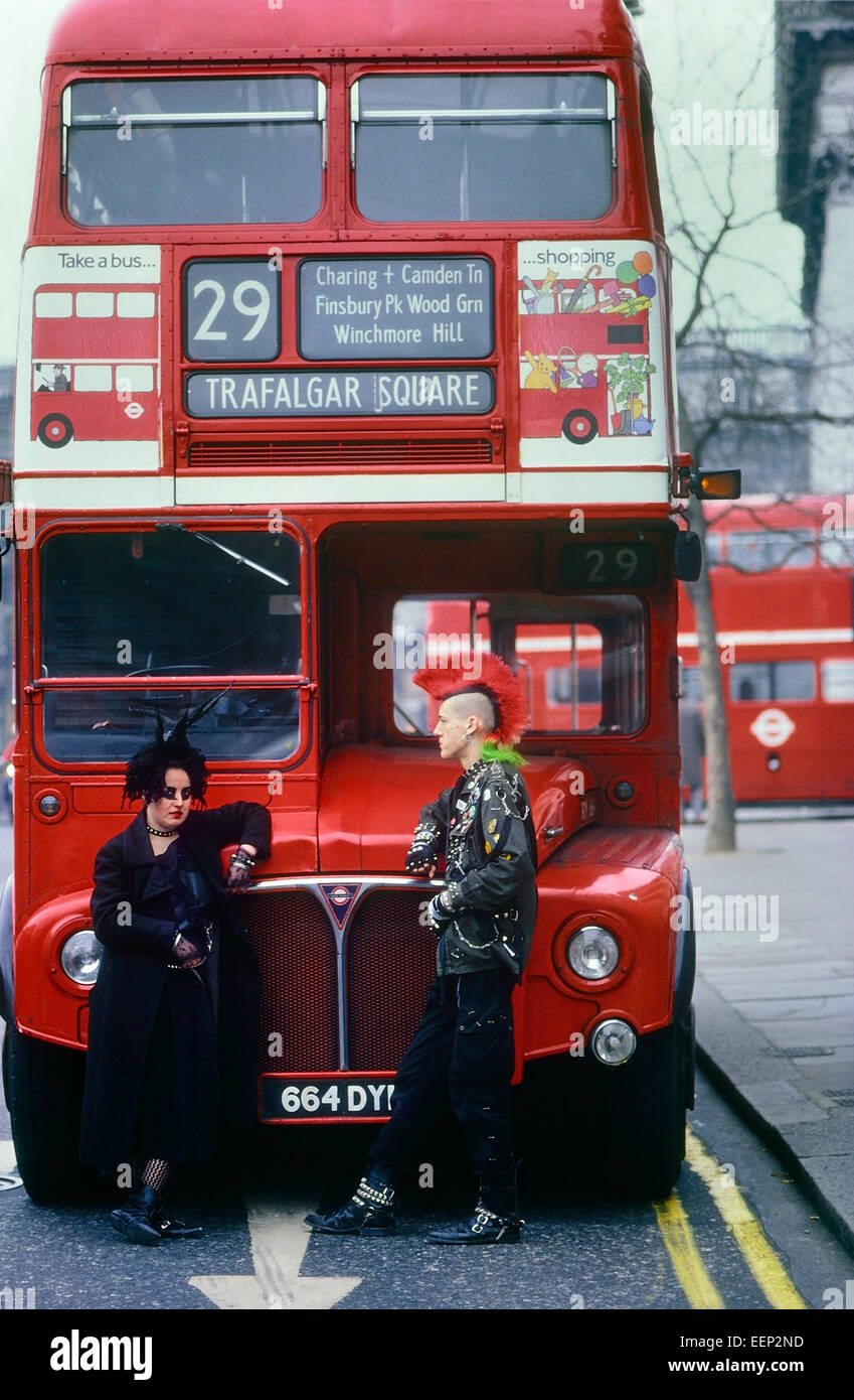Punk couple standing in front of a London Double-Decker Routemaster bus. Stock Photo