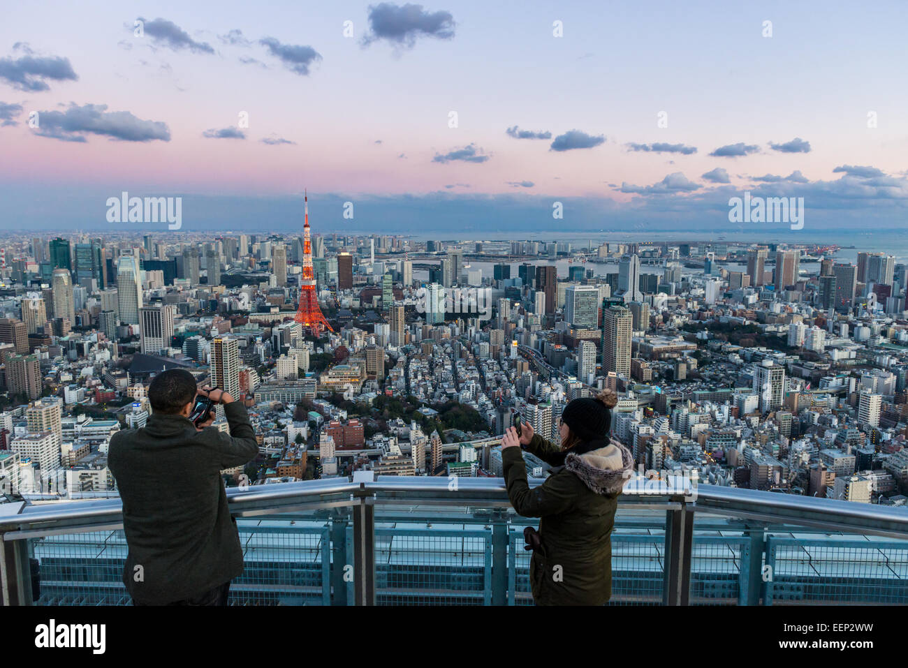 Tourists snap photos of Tokyo Tower from atop Mori Tower on January 2, 2015 in Tokyo, Japan. Stock Photo