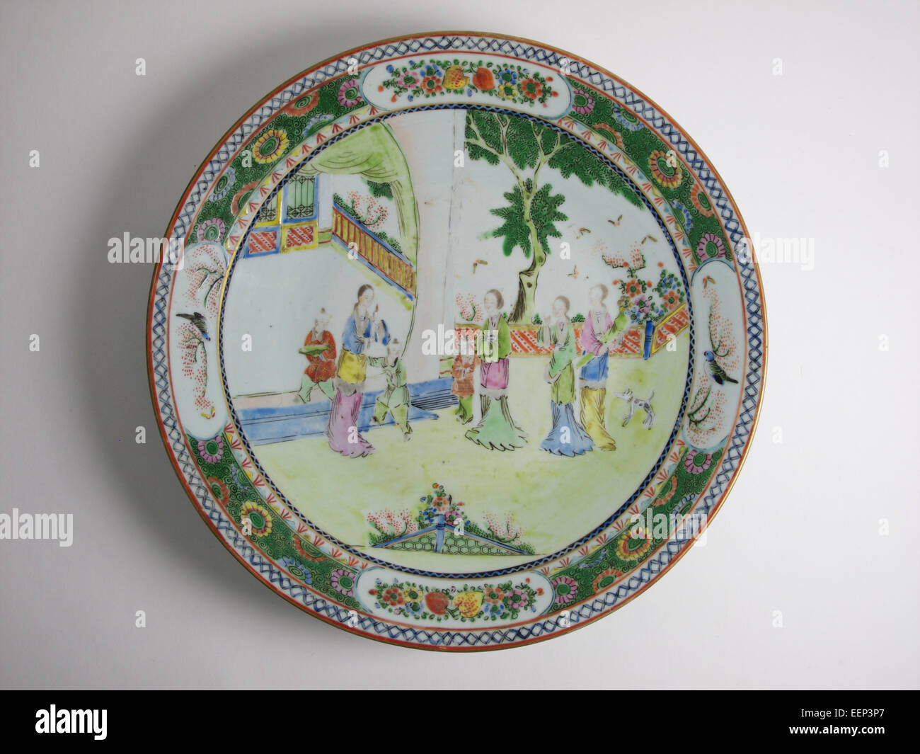 Antique Chinese famille verte porcelain dish, painted with figures within a garden. The dish measures 30.5 cm in diameter. Stock Photo