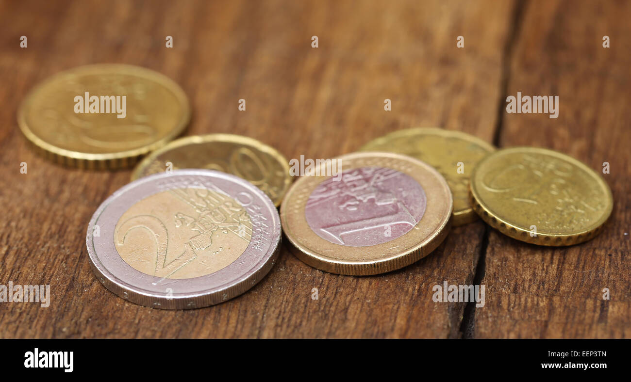 British Pound and Euro coins on wooden surface Stock Photo