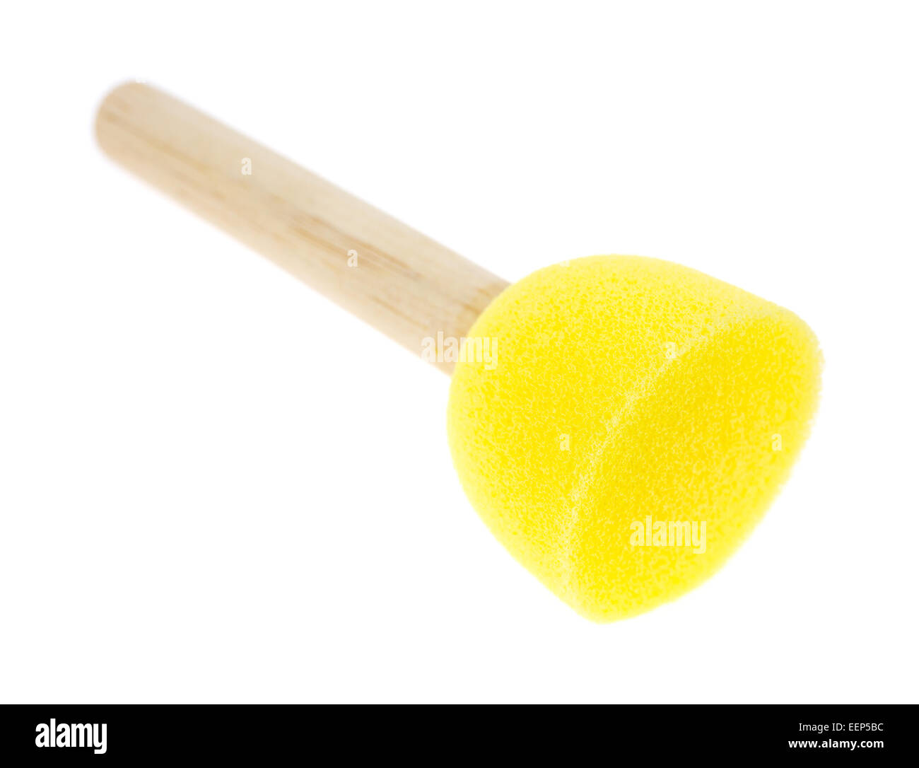 A large yellow foam brush used for stenciling on a white background. Stock Photo