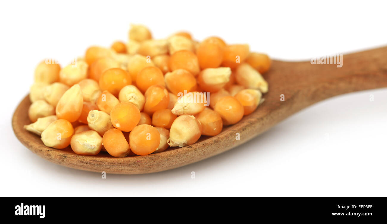 Corns with spoon over white background Stock Photo