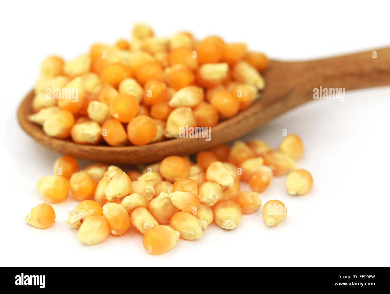 Corns with spoon over white background Stock Photo