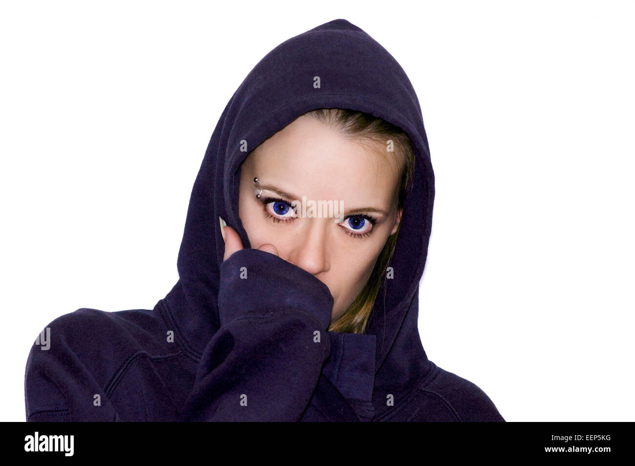 Beautiful woman portrait face concealed by her hand wearing a blue hooded sweatshirt with bright blue eyes. Stock Photo