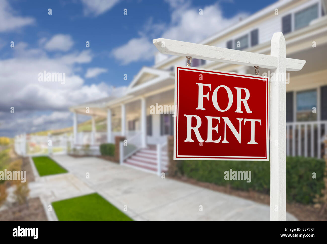 Red For Rent Real Estate Sign in Front of Beautiful House. Stock Photo