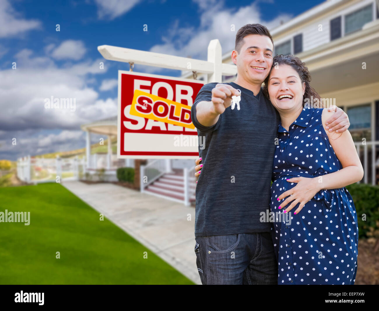 Happy Hispanic Couple In Front of New Home And Sold Real Estate Sign ...