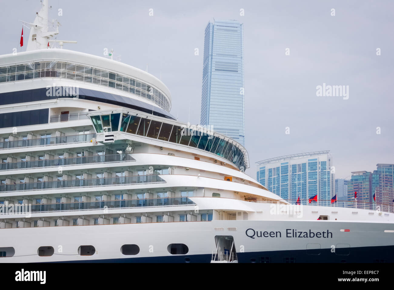 Cunard's Queen Elizabeth cruise ship docked in Hong Kong with the International Commerce Center ICC in the background Stock Photo