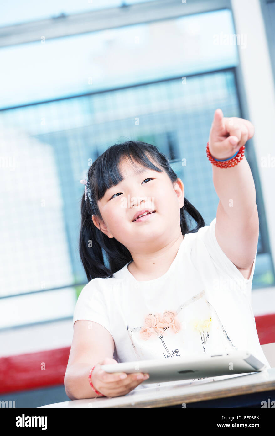 Asian girl at school pointing with her finger. Stock Photo