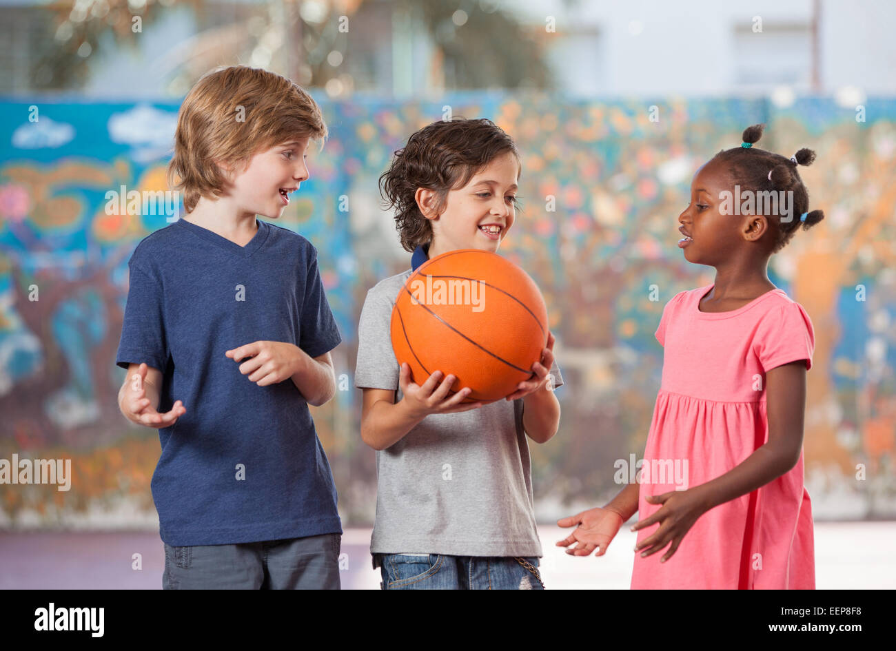 Smiling multi ethnic kids playing in schoolyard. Stock Photo