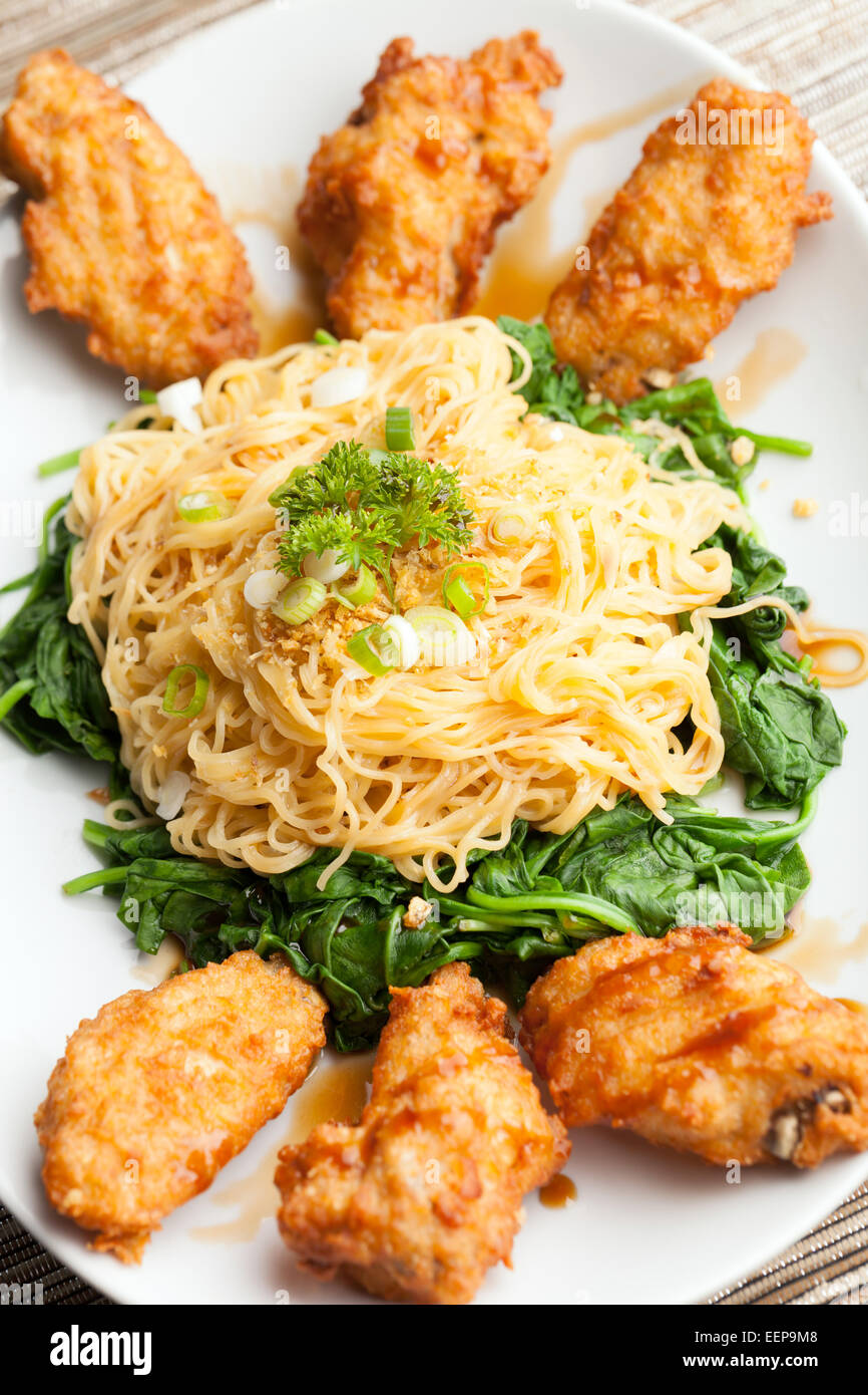Chicken Wings with Noodles and Spinach Stock Photo Alamy