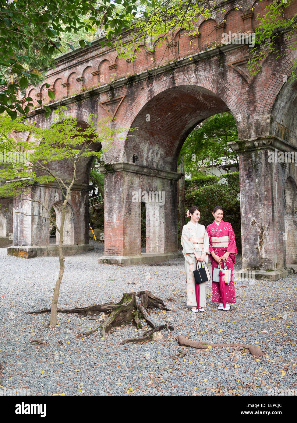 Two women in traditional Japanese costumes by the Nanzen-ji temple aqueduct Stock Photo