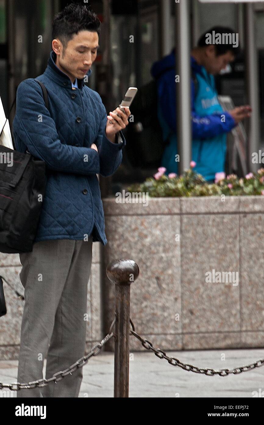 Tokyo, Japan. 17th Feb, 2015. A Japanese businessman uses a flip-phone on the street in Ginza shopping district on February 17, 2015, Tokyo, Japan. According to data from MM Research Institute Flip-phones sales increased for first time in seven years in Japan in 2014. In Japan flip-phones monthly rates are cheaper in comparison to smartphones which are more expensive than in other countries. Flip-phones sales rose 5.7% in 2014 whilst smartphone sales declined 5.3%. Credit:  Rodrigo Reyes Marin/AFLO/Alamy Live News Stock Photo