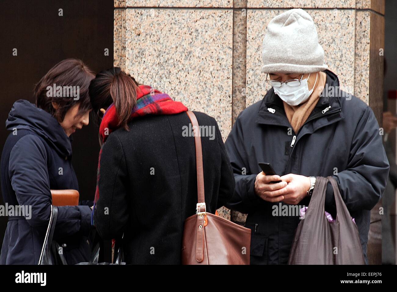 Tokyo, Japan. 17th Feb, 2015. A man uses a flip-phone on the street in Ginza shopping district on February 17, 2015, Tokyo, Japan. According to data from MM Research Institute Flip-phones sales increased for first time in seven years in Japan in 2014. In Japan flip-phones monthly rates are cheaper in comparison to smartphones which are more expensive than in other countries. Flip-phones sales rose 5.7% in 2014 whilst smartphone sales declined 5.3%. Credit:  Rodrigo Reyes Marin/AFLO/Alamy Live News Stock Photo