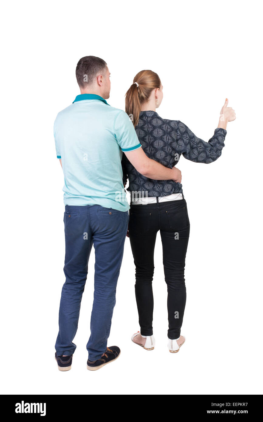 young couple pointing at wal Back view (woman and man). Rear view ...