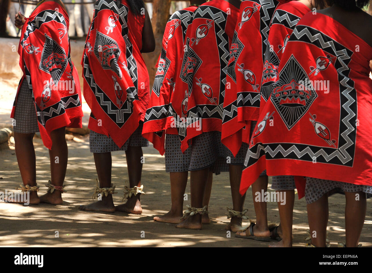 Colourful traditional red dresses of Swazi women dancers dancing in a row, performing a dance at Matsamo culture village, Swaziland Stock Photo