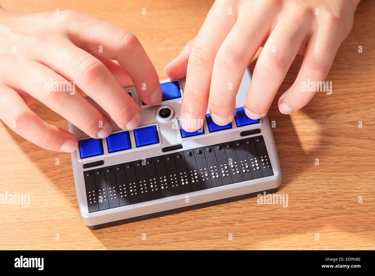 Student with visual impairment using her Braille display to communicate Stock Photo