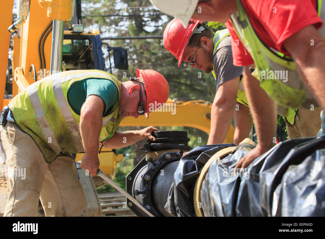 Construction workers using torque wrench to secure water main section with bolts Stock Photo Alamy