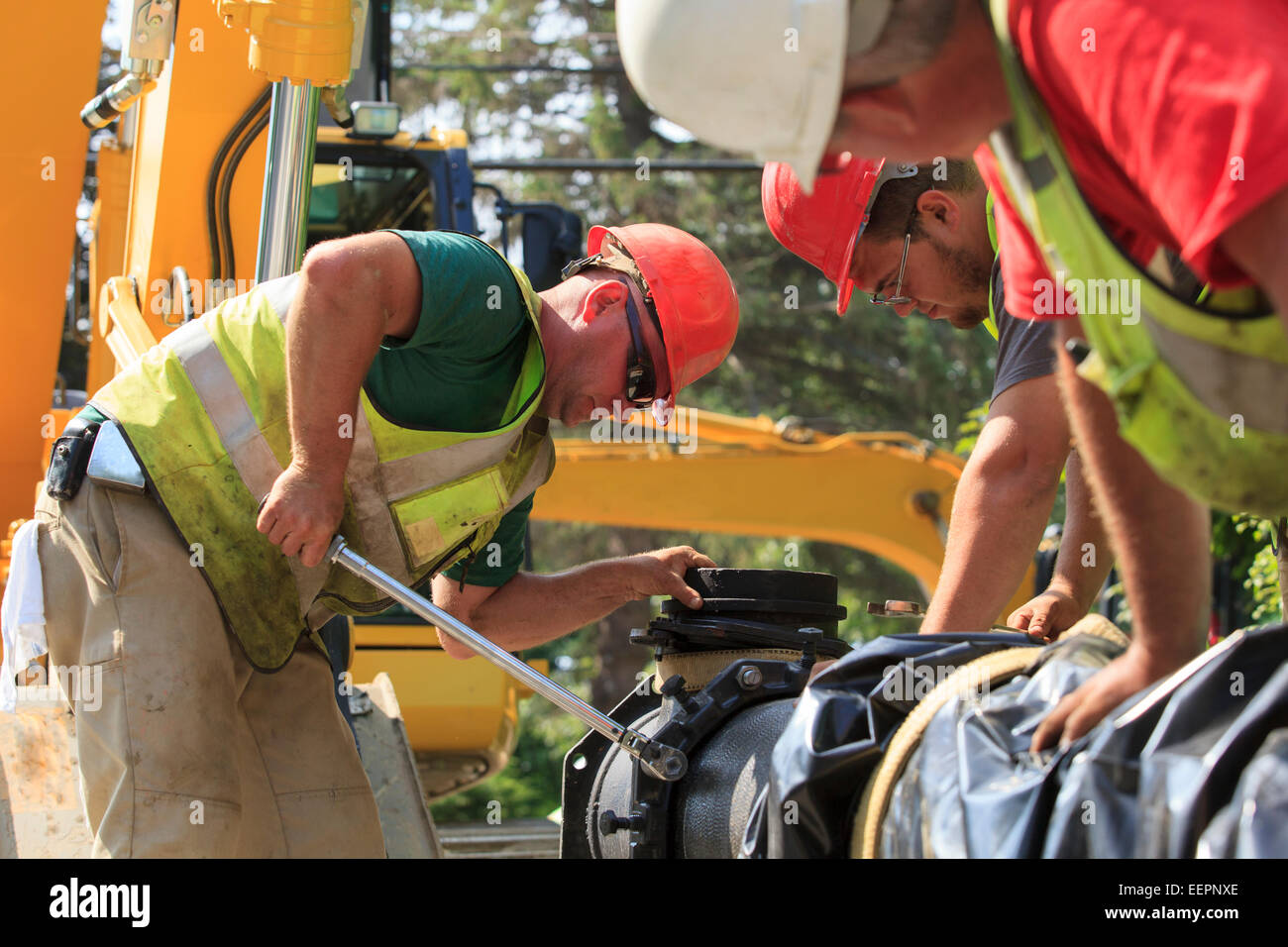 Construction workers using torque wrench to secure water main section with bolts Stock Photo Alamy