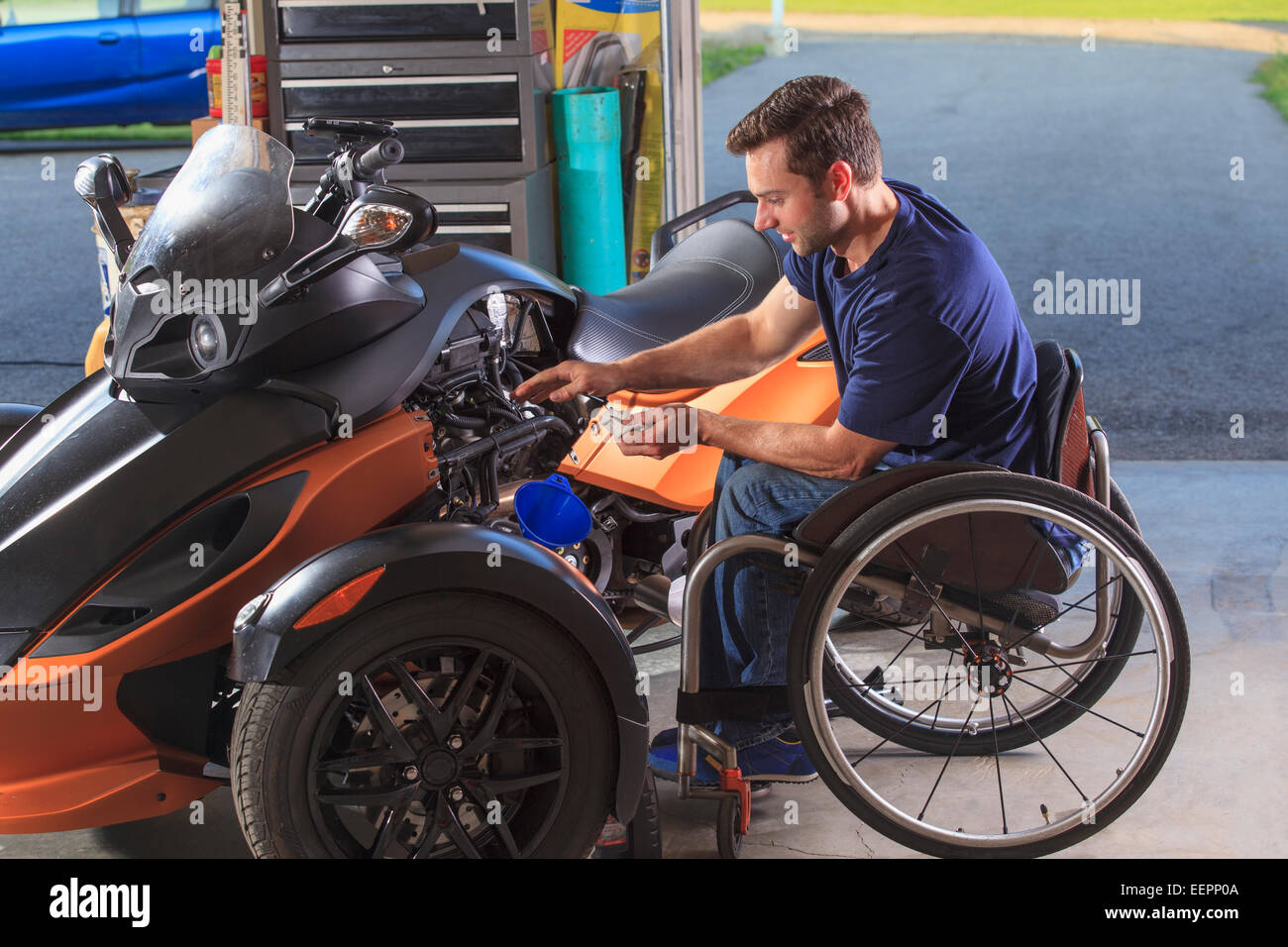 Man with spinal cord injury building his custom motorcycle Stock Photo