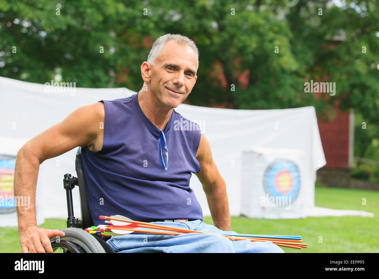 Man with spinal cord injury in wheelchair preparing for archery practice Stock Photo