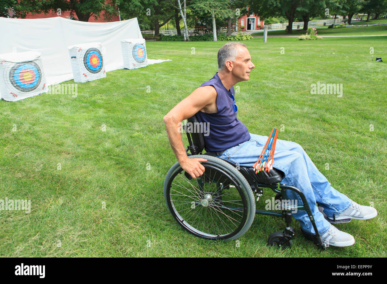 Man with spinal cord injury in wheelchair preparing for archery ...