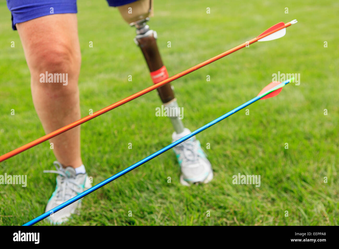 Woman with prosthetic leg preparing for archery practice Stock Photo