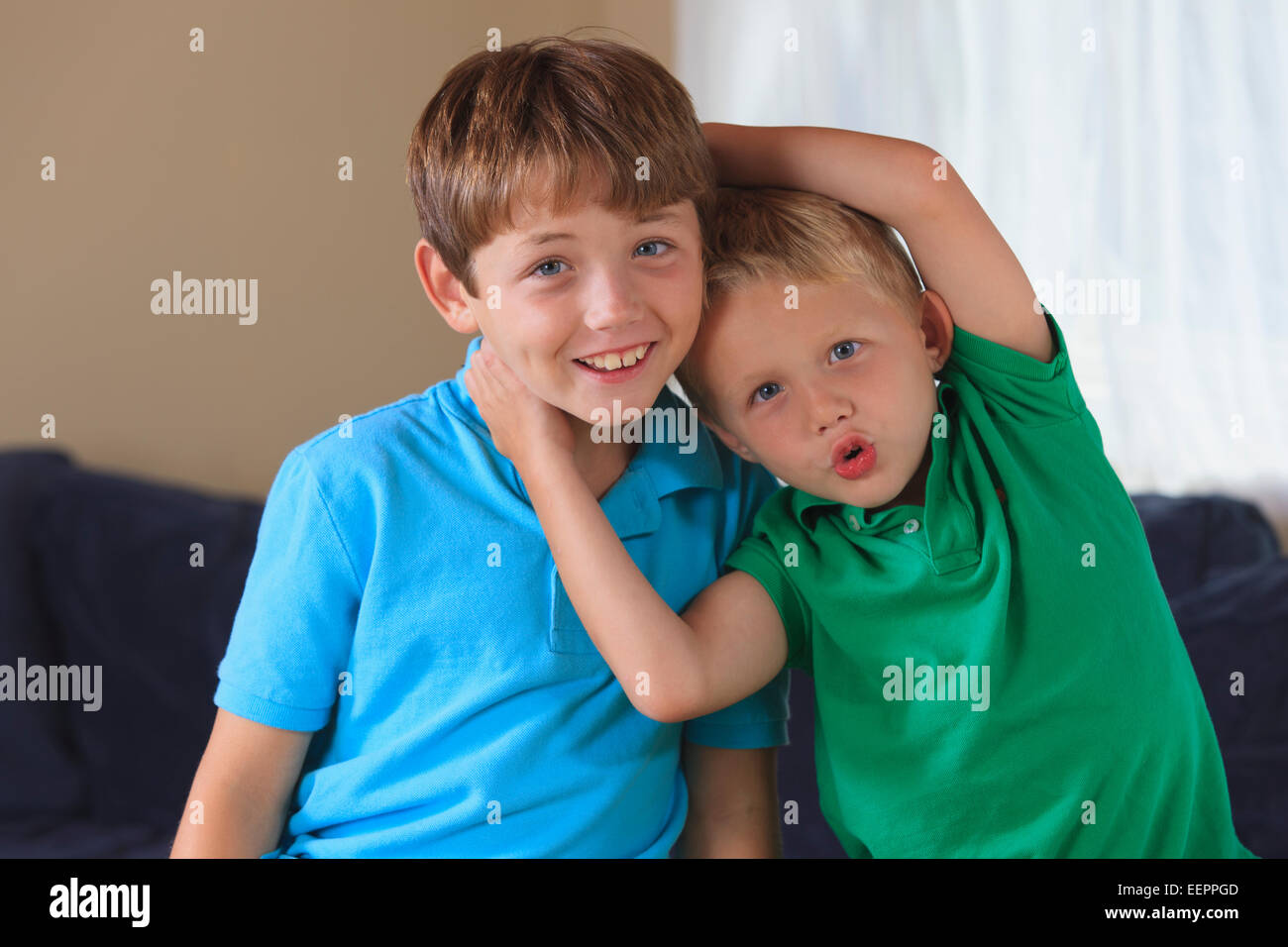 Boys with hearing impairments playing on their couch Stock Photo