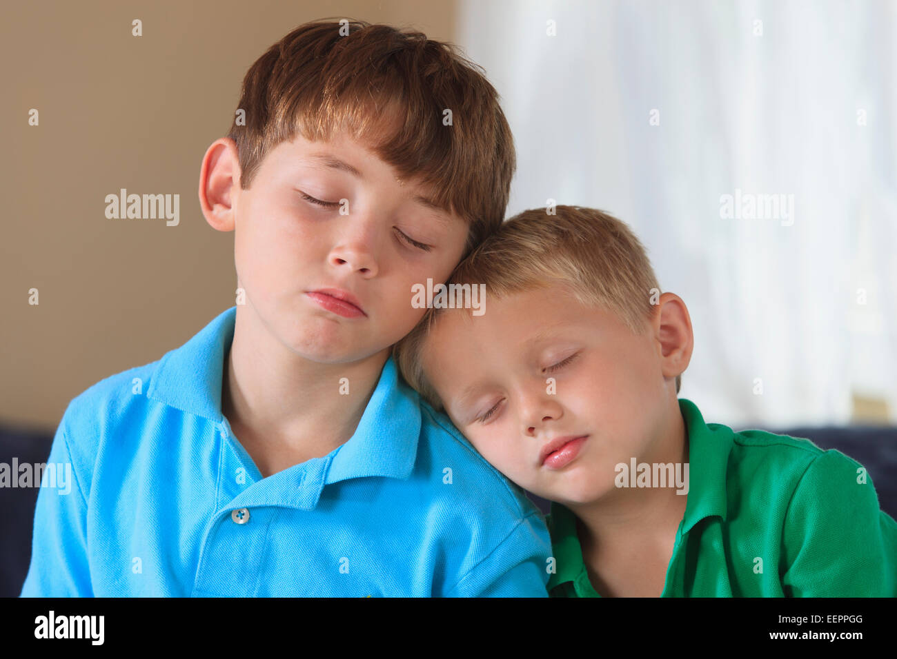 Boys with hearing impairments napping on their couch Stock Photo