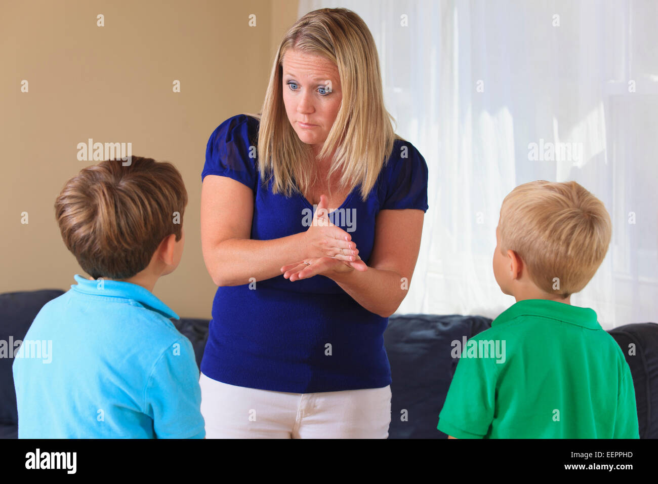 Mother and sons with hearing impairments signing 'stop' in American sign language Stock Photo